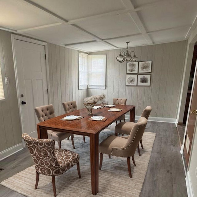 dining area with baseboards, an inviting chandelier, coffered ceiling, and wood finished floors