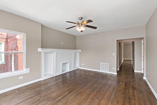 unfurnished living room with wood finished floors, visible vents, a wealth of natural light, and a ceiling fan