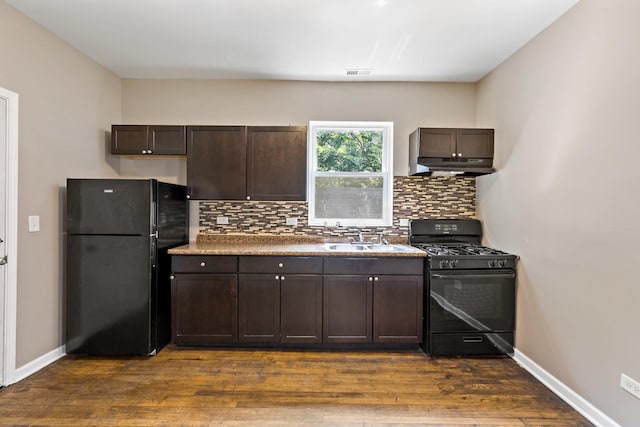 kitchen with black appliances, a sink, dark brown cabinetry, and under cabinet range hood
