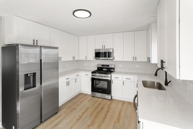 753 Rogers Rd, Romeoville, IL 60446 - kitchen with a sink, white cabinetry, tasteful backsplash, light wood-style flooring, and stainless steel appliances