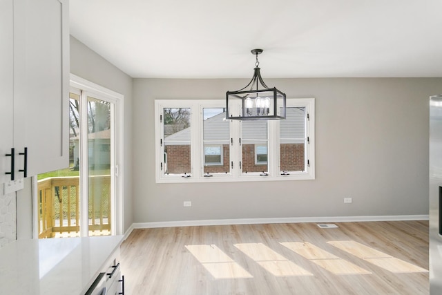 753 Rogers Rd, Romeoville, IL 60446 - unfurnished dining area with baseboards, a chandelier, and light wood-type flooring