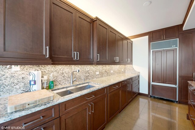 1300 N Lake Shore Dr Unit 25B, Chicago, IL 60610 - kitchen featuring a sink, paneled built in refrigerator, tasteful backsplash, light stone counters, and light tile patterned floors
