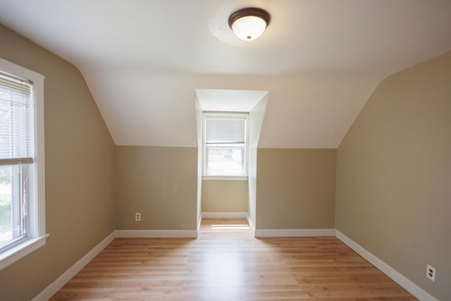 bonus room featuring baseboards, lofted ceiling, and light wood-type flooring