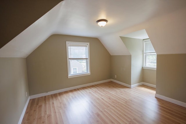 additional living space featuring light wood-style flooring, baseboards, and lofted ceiling
