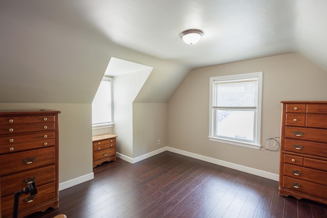 additional living space with baseboards, lofted ceiling, and dark wood-style flooring