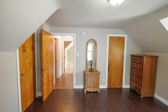 bonus room featuring baseboards, lofted ceiling, and dark wood finished floors