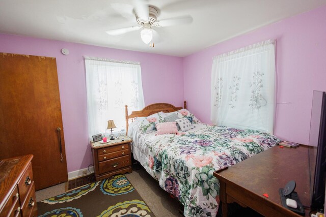 bedroom with a ceiling fan, dark colored carpet, baseboards, and visible vents
