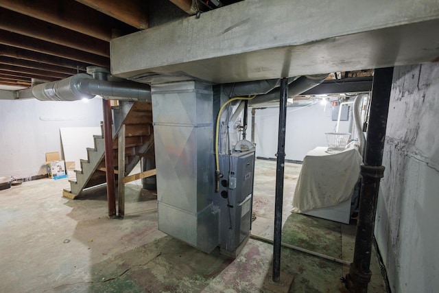 unfinished below grade area featuring stairs and heating unit