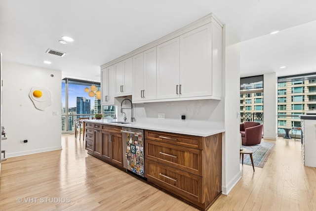 21 E Huron St Unit 1806, Chicago, IL 60611 - bar featuring stainless steel dishwasher, light wood-style floors, expansive windows, a sink, and baseboards