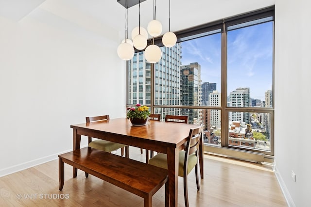 21 E Huron St Unit 1806, Chicago, IL 60611 - dining space featuring a view of skyline, light wood-type flooring, and baseboards