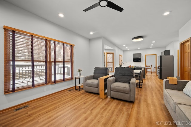 living area featuring light wood-style flooring, visible vents, baseboards, ceiling fan, and recessed lighting