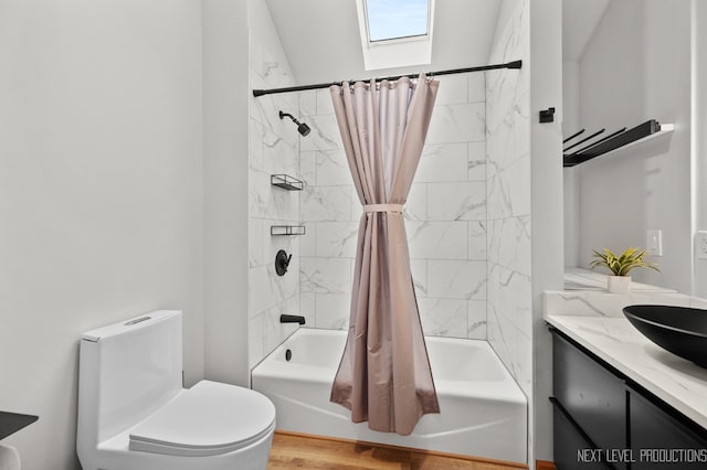 bathroom with shower / tub combo with curtain, toilet, vanity, and a skylight