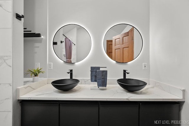 full bathroom with double vanity and a sink