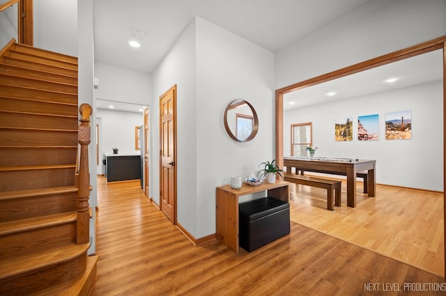 hall with baseboards, stairs, recessed lighting, and light wood finished floors