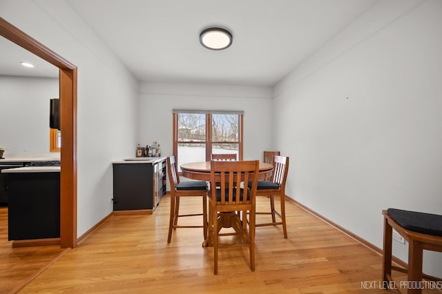dining area featuring baseboards and light wood finished floors