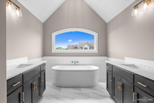 483 Deerfield Dr, Oswego, IL 60543 - bathroom featuring a wainscoted wall, vaulted ceiling, two vanities, marble finish floor, and a freestanding bath