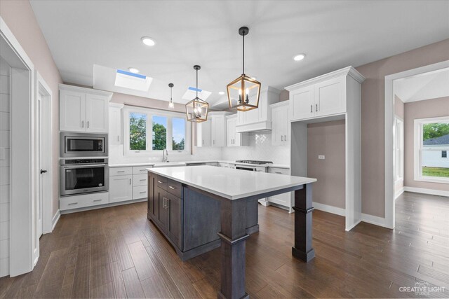 483 Deerfield Dr, Oswego, IL 60543 - kitchen featuring white cabinets, stainless steel appliances, a skylight, and plenty of natural light