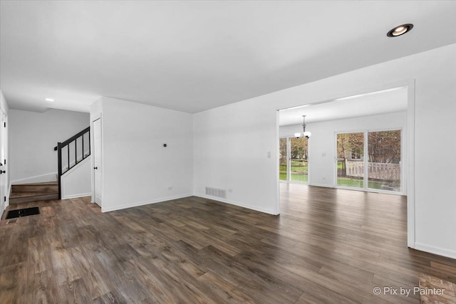 413 Edinburgh Ln, West Dundee, IL 60118 - unfurnished living room featuring baseboards, dark wood-type flooring, stairs, and a chandelier