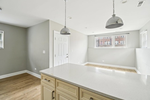 kitchen featuring baseboards, visible vents, decorative light fixtures, and light wood-type flooring