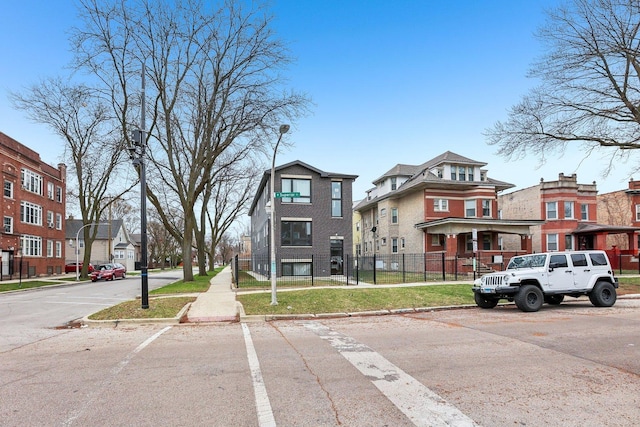 view of road featuring a residential view, sidewalks, curbs, and street lighting