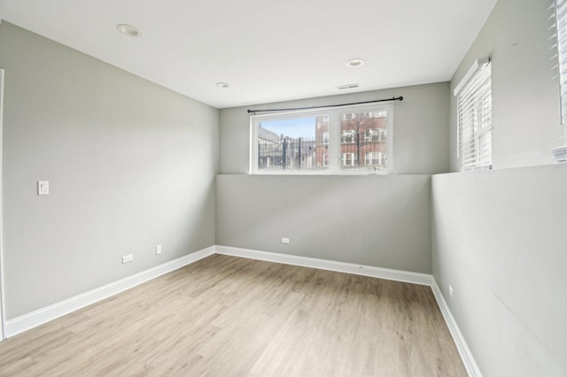 empty room featuring baseboards, visible vents, and wood finished floors