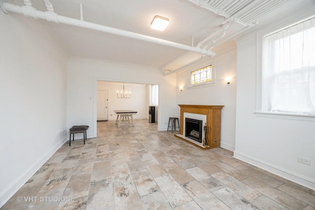 7001 W Altgeld St Unit G, Chicago, IL 60707 - unfurnished living room with light stone finish flooring, a fireplace with raised hearth, a chandelier, baseboards, and ornamental molding