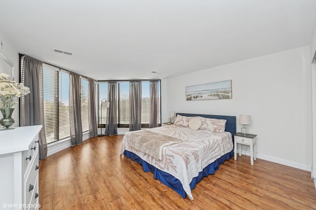 bedroom with visible vents, light wood-style flooring, and multiple windows