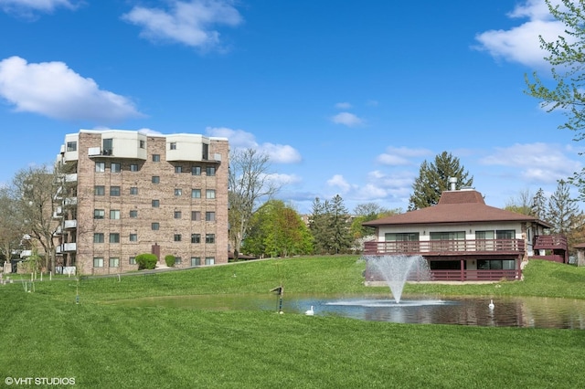 view of community featuring a water view and a yard