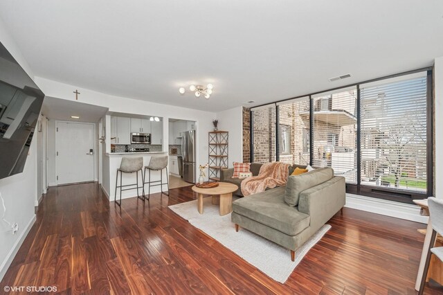 living area with baseboards, dark wood-style flooring, and visible vents