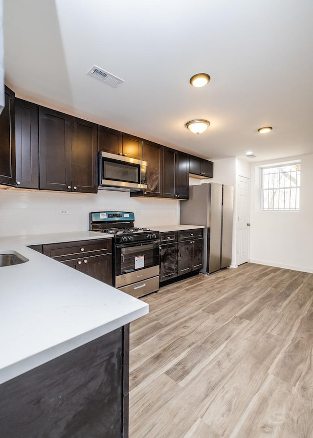 kitchen with visible vents, light countertops, light wood-type flooring, and stainless steel appliances