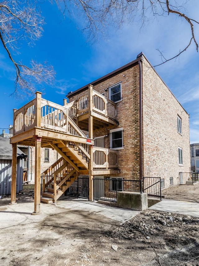 back of property with brick siding and stairway