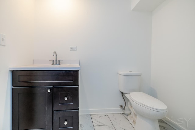 half bath with baseboards, marble finish floor, toilet, and vanity