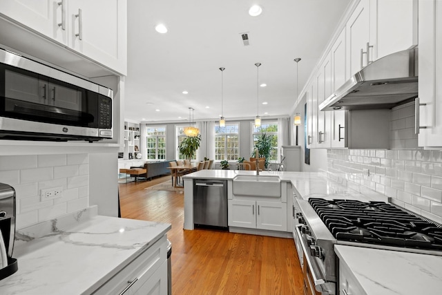 5486 S Woodlawn Ave Unit 3, Chicago, IL 60615 - kitchen featuring under cabinet range hood, a sink, white cabinets, a peninsula, and appliances with stainless steel finishes