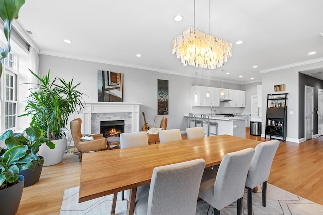 5486 S Woodlawn Ave Unit 3, Chicago, IL 60615 - dining area featuring a notable chandelier, a high end fireplace, light wood-style floors, and recessed lighting