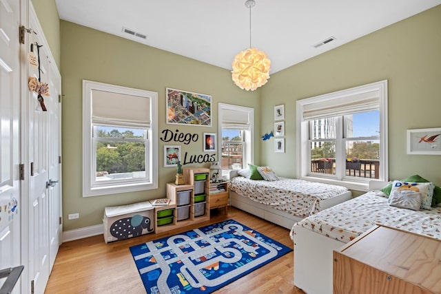 5486 S Woodlawn Ave Unit 3, Chicago, IL 60615 - bedroom with baseboards, light wood-style floors, and visible vents