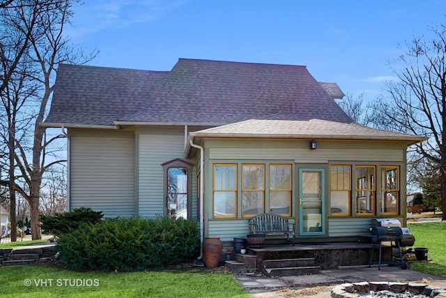 rear view of property featuring a shingled roof