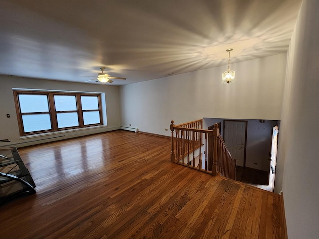 empty room with wood finished floors, ceiling fan, and baseboards