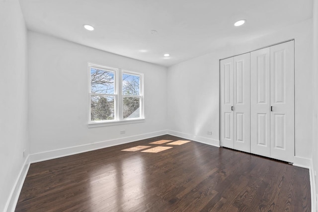 unfurnished bedroom featuring wood finished floors, baseboards, a closet, and recessed lighting
