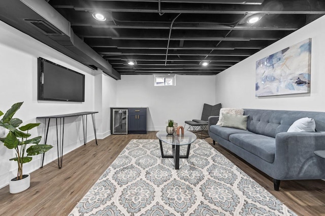 living area with wine cooler, visible vents, and wood finished floors