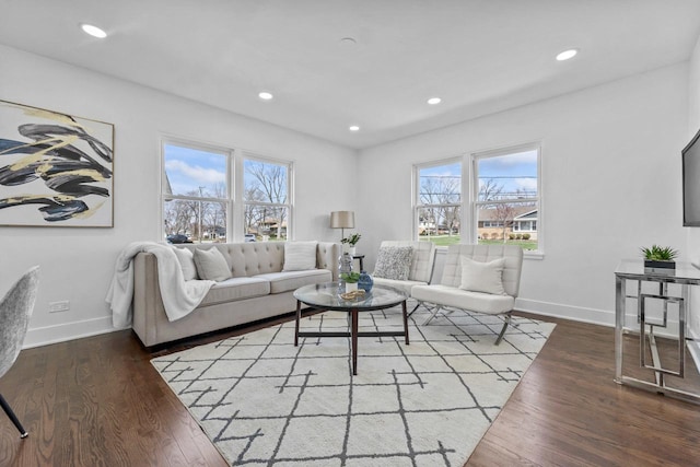 living area featuring baseboards, wood finished floors, and a healthy amount of sunlight