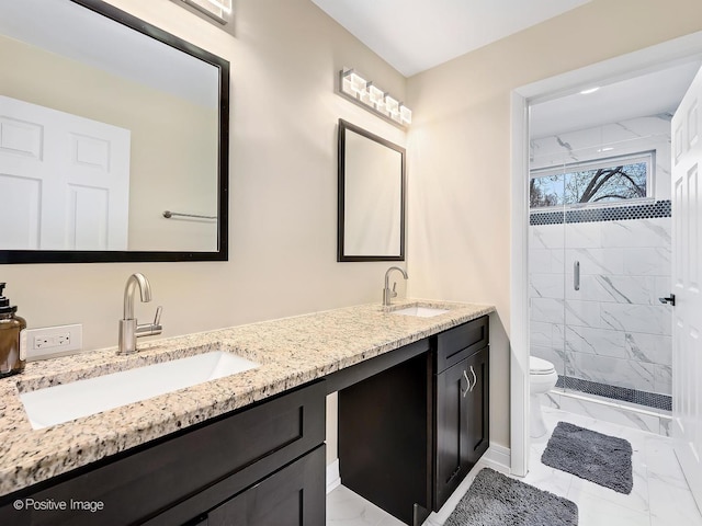 full bathroom featuring a shower stall, marble finish floor, toilet, and a sink