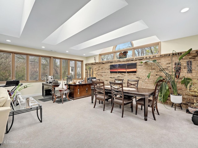 dining room featuring carpet, a healthy amount of sunlight, and a skylight