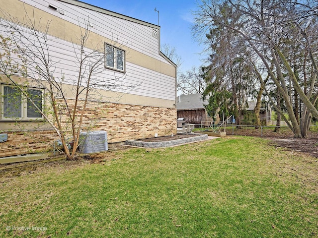 view of yard with fence and central AC unit