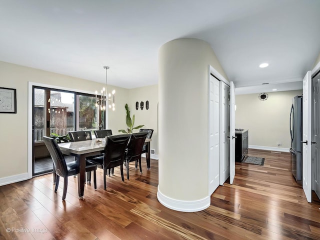 dining area featuring recessed lighting, a notable chandelier, baseboards, and dark wood-style flooring