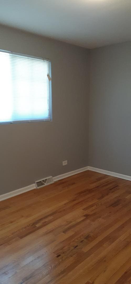15831 Dante Dr, South Holland, IL 60473 - empty room with wood finished floors and baseboards