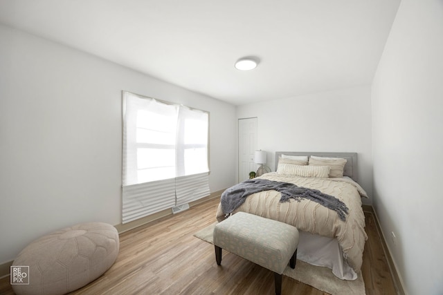 bedroom featuring visible vents, baseboards, and wood finished floors