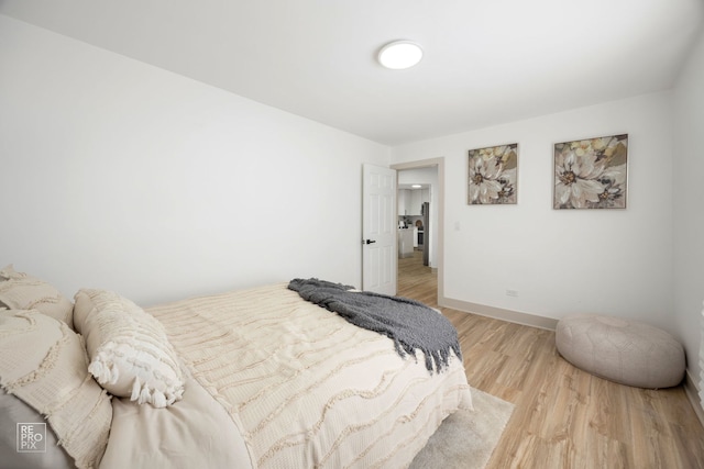 bedroom featuring baseboards and light wood-style floors