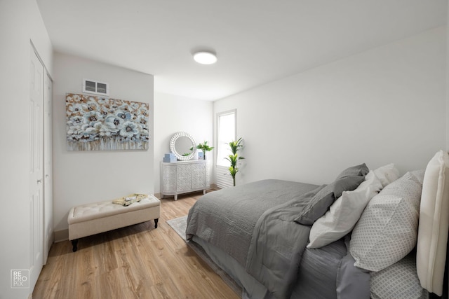 bedroom featuring a closet, visible vents, and light wood finished floors