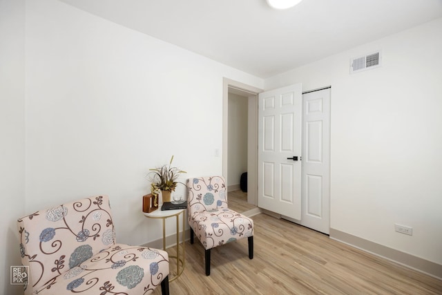 sitting room featuring light wood finished floors, baseboards, and visible vents