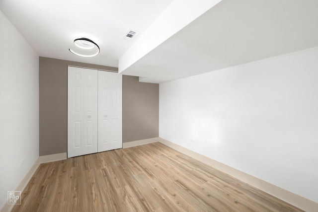 unfurnished bedroom featuring a closet, baseboards, visible vents, and light wood finished floors